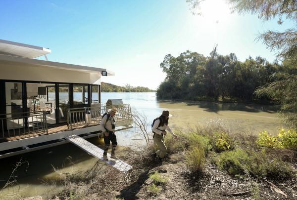 Two people step off a houseboat on the banks of the Murray River, Renmark, South Australia © Tourism Australia
