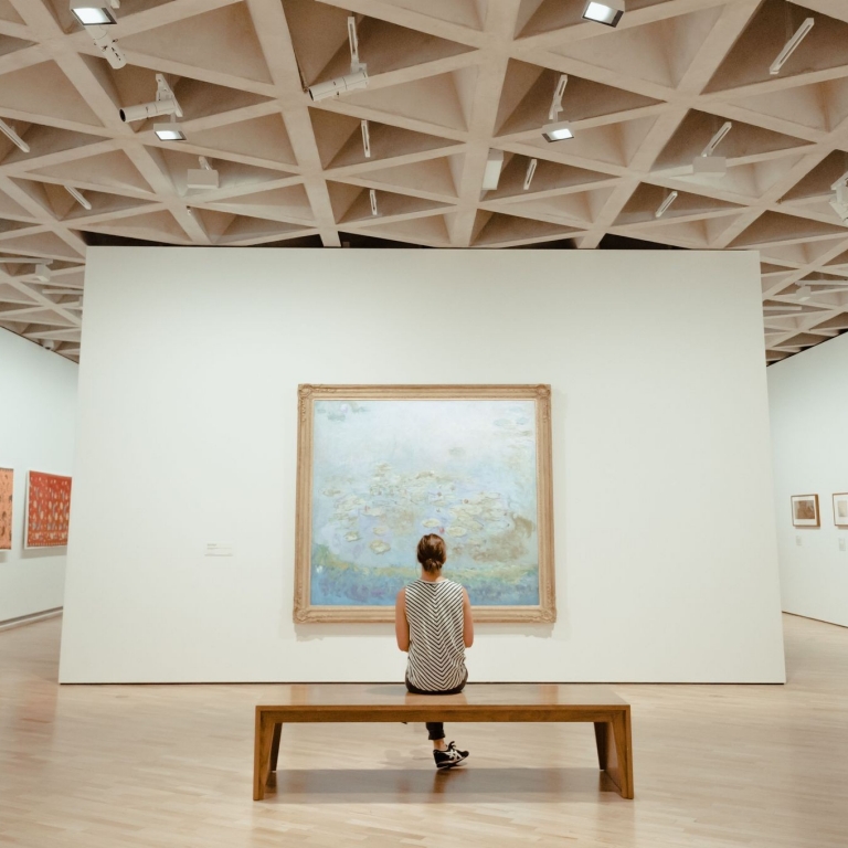 A woman sitting, admiring an artwork in the National Gallery of Australia, Canberra, Australian Capital Territory © Tourism Australia
