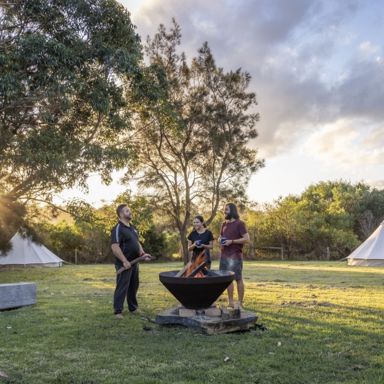 Tour surrounding firepit, Ngaran Ngaran Culture Awareness, Eurobodalla National Park, New South Wales © Tourism Australia