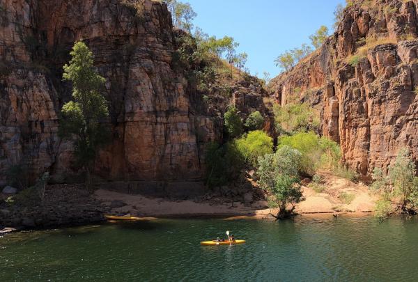Kayaker by shore edge viewing rock formations with Nitmiluk Tours, Katherine, Northern Territory © Tourism Australia