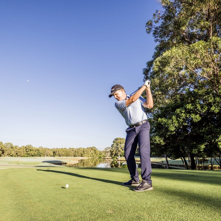 Man taking a swing at Noosa Springs Golf and Spa Resort, Noosa Heads, Queensland © Tourism Australia