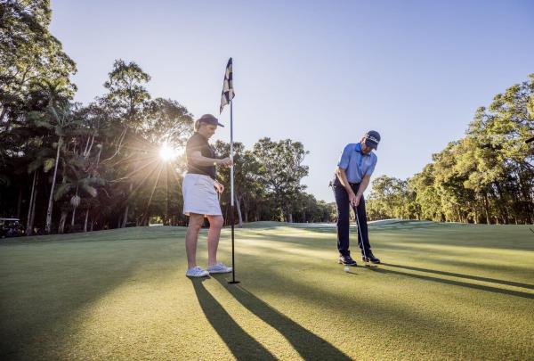 Two people playing golf at Noosa Springs Golf and Spa Resort, Noosa Heads, Queensland © Tourism Australia
