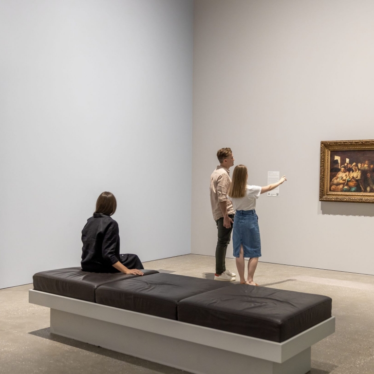 couple looking at painting with lady talent in foreground at the European Masterpieces exhibition., QAGOMA, Queensland Art Gallery, Brisbane, Queensland © Tourism Australia