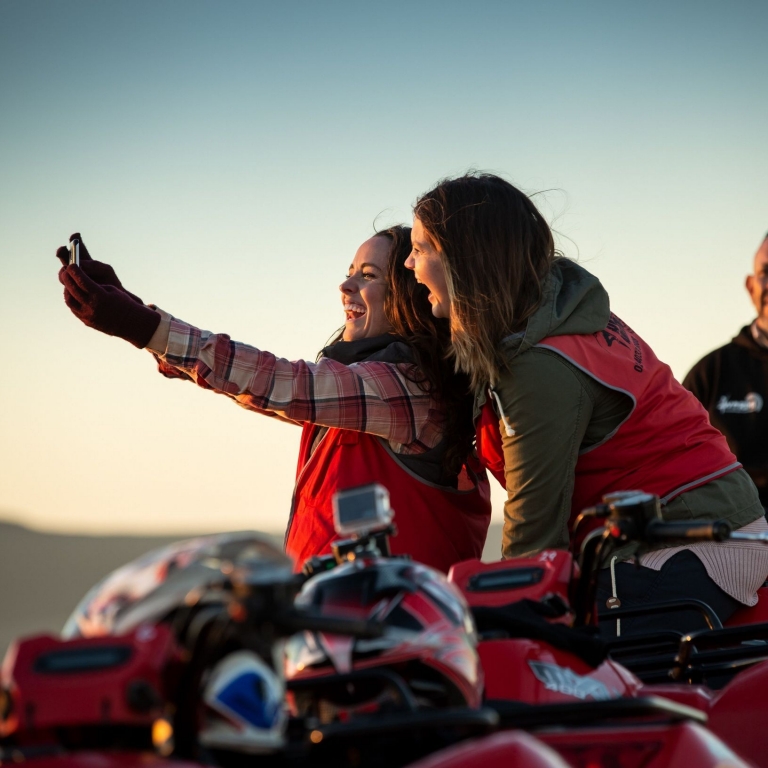 Quad bike riders take a selfie on the sand dunes at Stockton Beach on a Sand Dune Adventures tour, Port Stephens, New South Wales © Tourism Australia