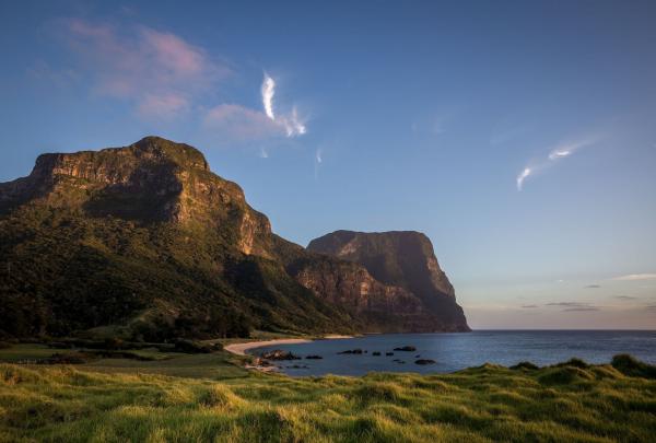 A stunning view stretches across the calm, clear bay towards the towering form of Mount Gower on Lord Howe Island, New South Wales © Tourism Australia
