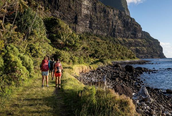 A group of hikers make their way along the coastal track past Little Island on Lord Howe Island, Seven Peaks Walk, Pinetrees Lodge, Lord Howe Island, New South Wales © Tourism Australia