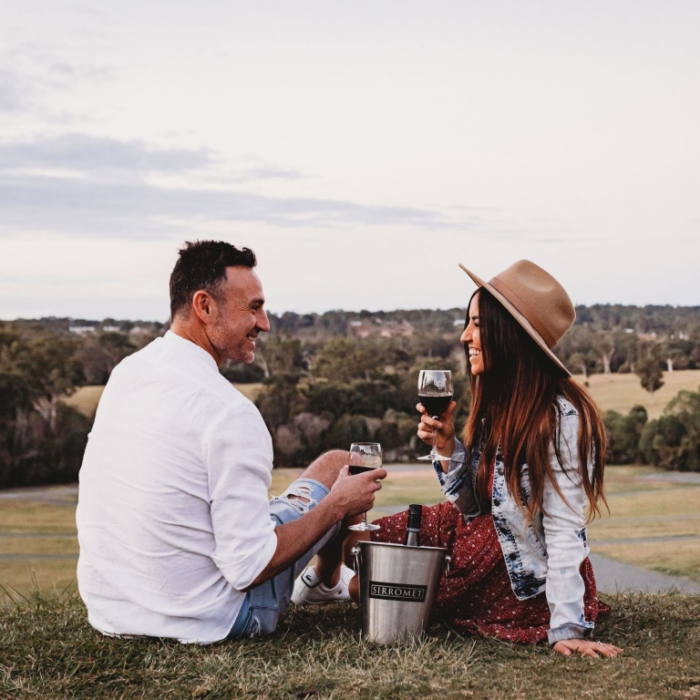 A couple enjoy a picnic with some wine at Sirromet Wines, Mount Cotton, Brisbane, Queensland © Tourism Australia