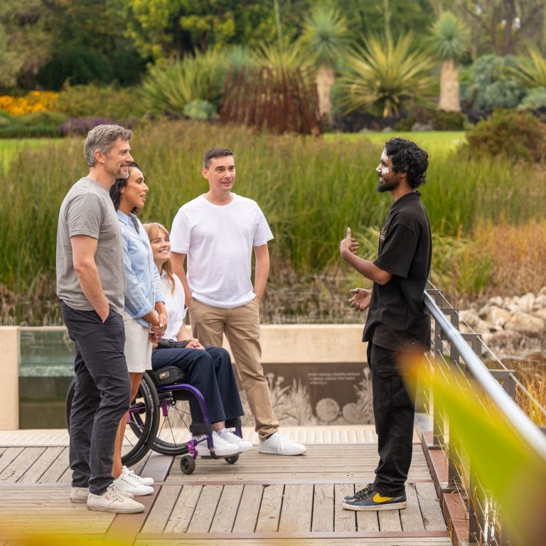 An Indigenous tour guide from Southern Cultural Immersion leads a group through Adelaide Botanic Gardens, Adelaide, South Australia © Tourism Australia