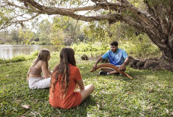 Guide leading a couple of girls through a cultural tour, Taribelang Bunda Cultural Tours, Bundaberg, Queensland © Tourism Australia