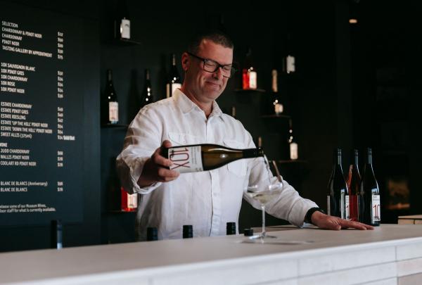 Man pouring a wine tasting Pinot Noir at Ten Minutes by Tractor, Main Ridge, Mornington Peninsula, Victoria © Tourism Australia