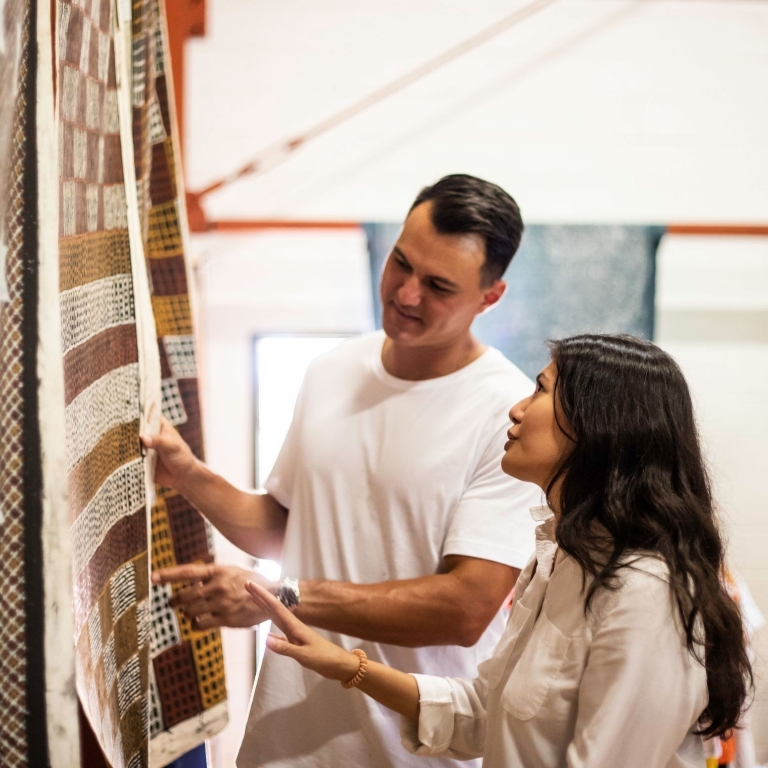 Couple looking at artwork on a Tiwi Tours, Wurrumiyanga, Bathurst Island, Northern Territory © Tourism NT