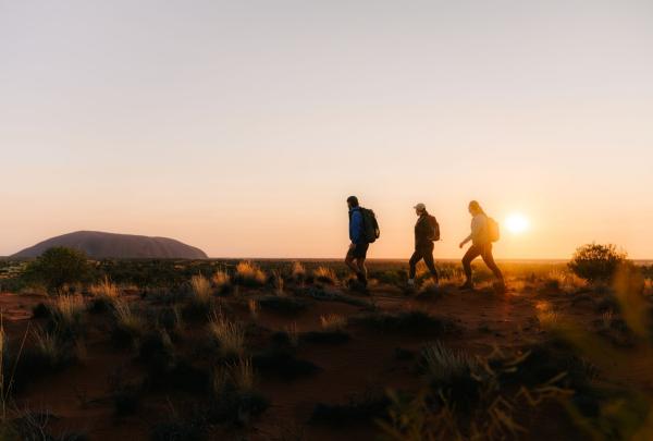 Three people walking at sunrise, Uluṟu Kata Tjuṯa Signature Walk, Uluṟu Kata Tjuṯa National Park, Northern Territory © Michael Peters